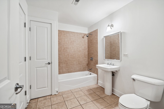 full bathroom with tile patterned flooring, tiled shower / bath combo, toilet, and sink