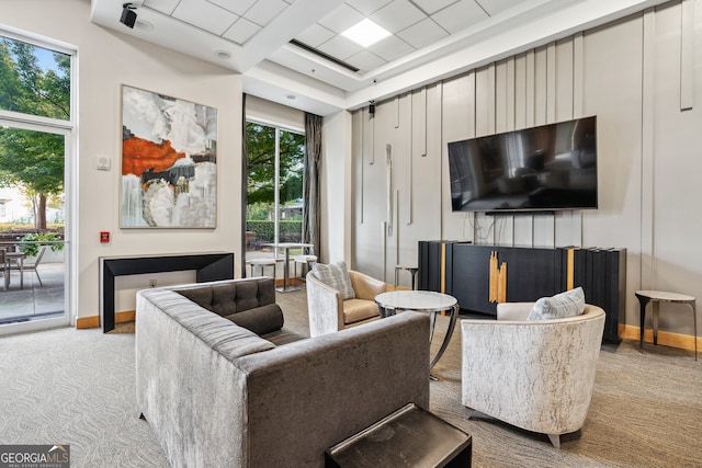 carpeted living room with a drop ceiling and plenty of natural light