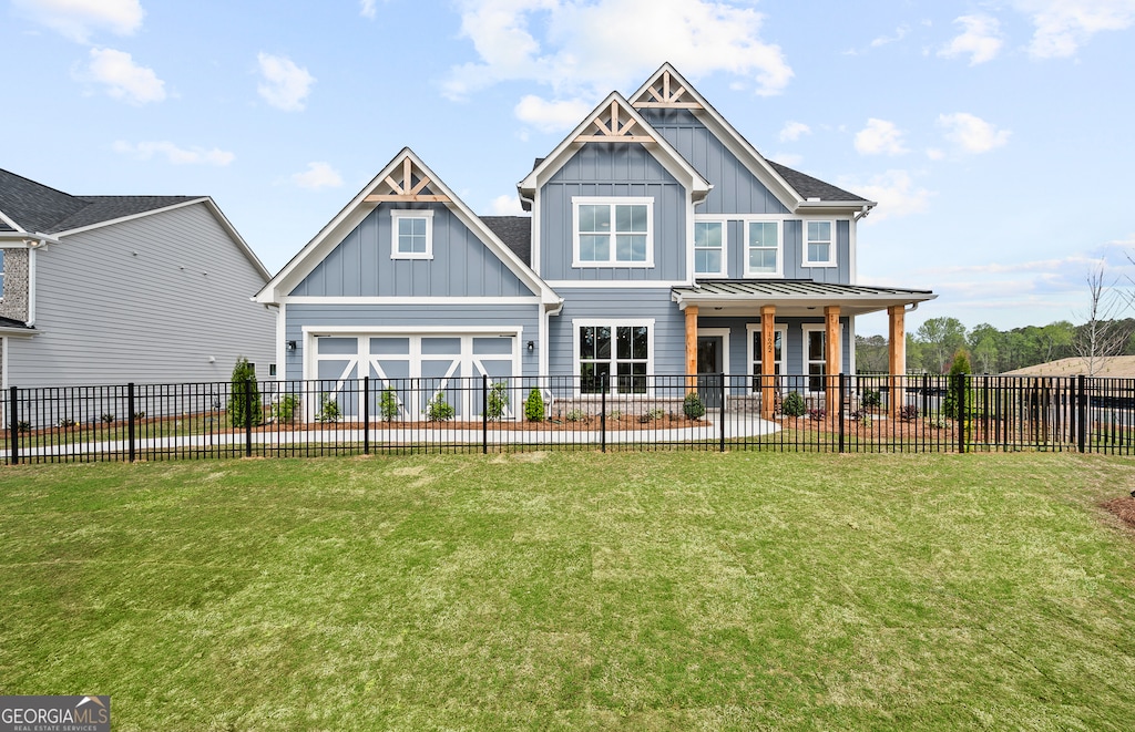 rear view of property with a garage, a lawn, and a porch