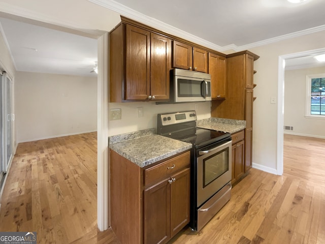 kitchen featuring light hardwood / wood-style flooring, ornamental molding, stainless steel appliances, and light stone counters