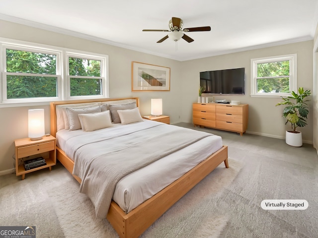 carpeted bedroom with ceiling fan, ornamental molding, and multiple windows