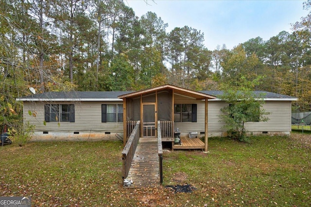 manufactured / mobile home featuring a deck, a front lawn, and a sunroom