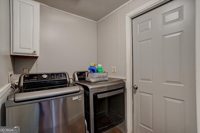 laundry area featuring cabinets, ornamental molding, washer and dryer, and a textured ceiling