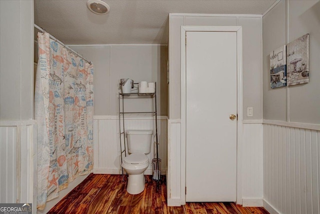 bathroom featuring wood-type flooring, a textured ceiling, and toilet