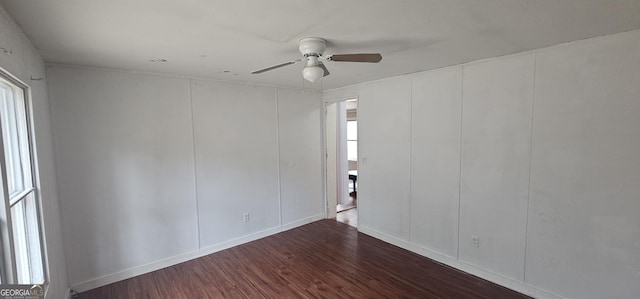 unfurnished room featuring dark wood-type flooring and ceiling fan