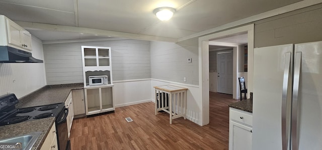 kitchen featuring black electric range oven, sink, stainless steel refrigerator, wood-type flooring, and white cabinets