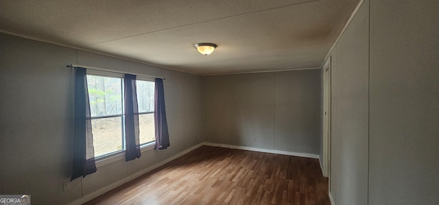 spare room featuring hardwood / wood-style flooring and crown molding