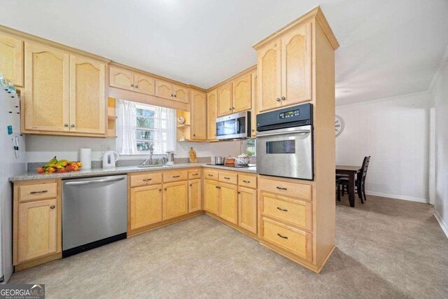 kitchen with sink, appliances with stainless steel finishes, light carpet, and light brown cabinets