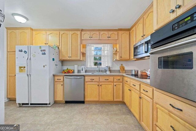 kitchen with stainless steel appliances, sink, and light brown cabinetry