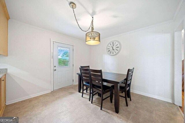 dining area featuring ornamental molding and light colored carpet