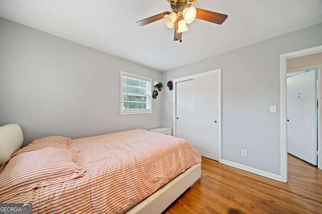 bedroom featuring hardwood / wood-style flooring, a closet, and ceiling fan