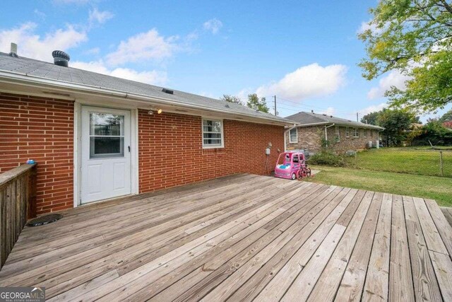 wooden terrace featuring a yard