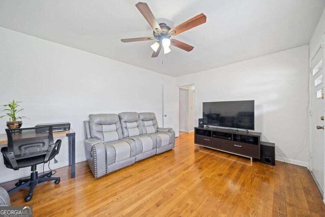 living room featuring light wood-type flooring and ceiling fan