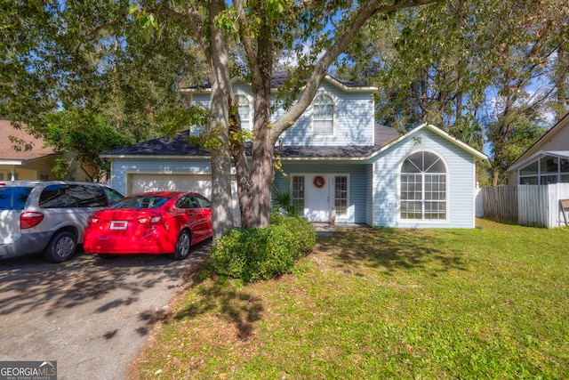 view of front of home with a front yard and a garage