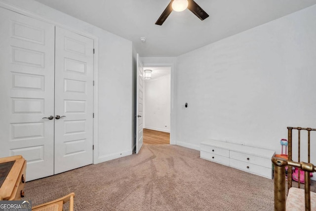 bedroom with a closet, ceiling fan, and light colored carpet