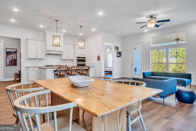 dining room featuring crown molding, light hardwood / wood-style flooring, and ceiling fan