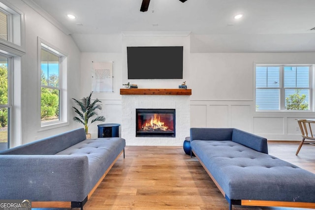 living room featuring ceiling fan, ornamental molding, and light wood-type flooring