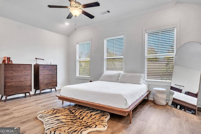 bedroom featuring light hardwood / wood-style flooring, multiple windows, vaulted ceiling, and ceiling fan