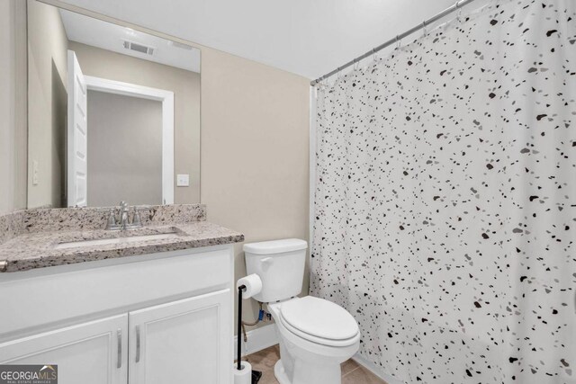 bathroom featuring vanity, toilet, walk in shower, and tile patterned flooring