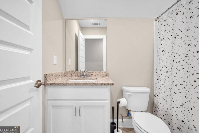 bathroom featuring vanity, toilet, and walk in shower