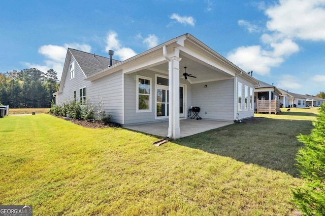 rear view of house with a patio area, a lawn, and ceiling fan