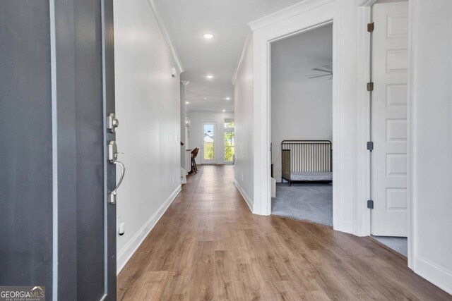 hall featuring light hardwood / wood-style floors and crown molding