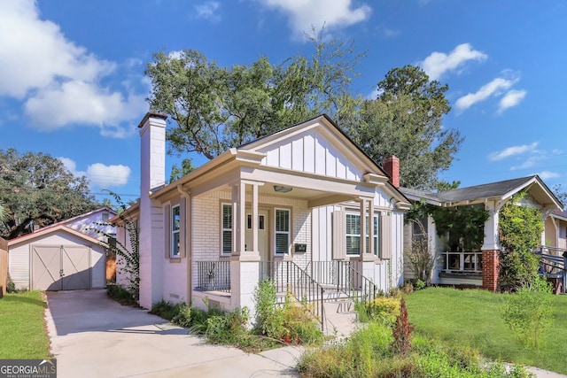 bungalow-style house with covered porch, a storage shed, and a front yard