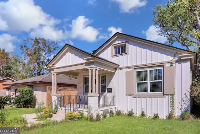 view of front facade with covered porch, a garage, and a front lawn