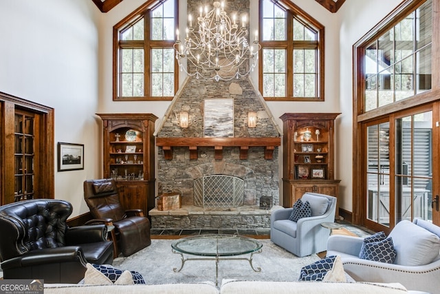 living room featuring a stone fireplace, a towering ceiling, and an inviting chandelier