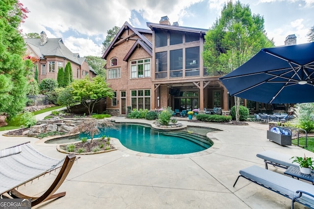 view of swimming pool with a patio area and a sunroom