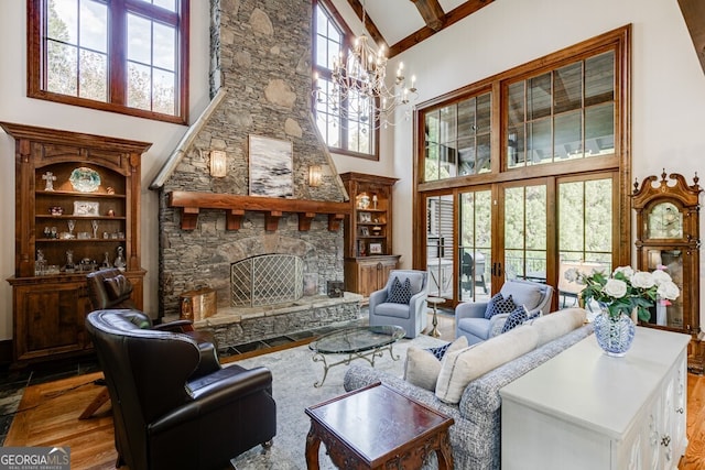 living room with an inviting chandelier, high vaulted ceiling, hardwood / wood-style flooring, beamed ceiling, and a fireplace