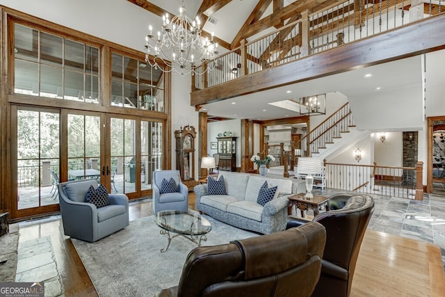 living room featuring hardwood / wood-style flooring, a chandelier, high vaulted ceiling, and french doors