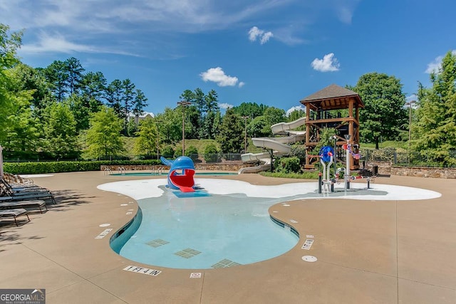 view of swimming pool featuring a patio area and a playground