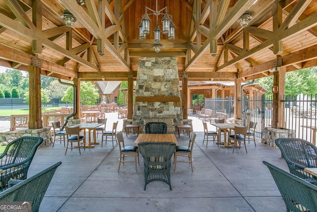 view of patio / terrace featuring a gazebo and an outdoor stone fireplace