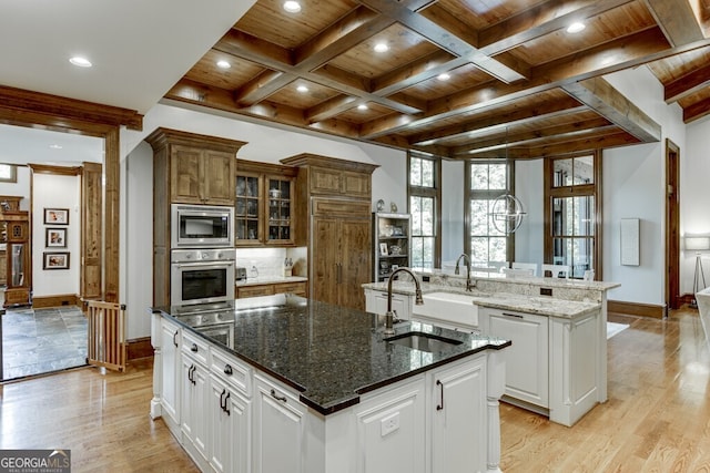 kitchen featuring white cabinetry, wooden ceiling, appliances with stainless steel finishes, and a center island with sink