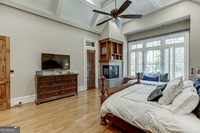 bedroom with coffered ceiling, ceiling fan, beam ceiling, and light hardwood / wood-style flooring