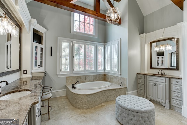 bathroom featuring vanity, beamed ceiling, an inviting chandelier, and a high ceiling