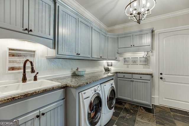 laundry area featuring sink, a chandelier, cabinets, ornamental molding, and washing machine and clothes dryer