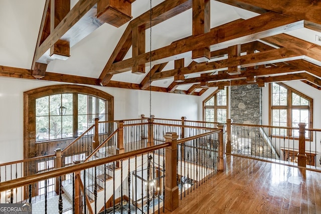 interior space featuring beam ceiling, wood-type flooring, and high vaulted ceiling