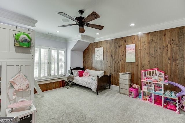 carpeted bedroom with crown molding, wooden walls, and ceiling fan