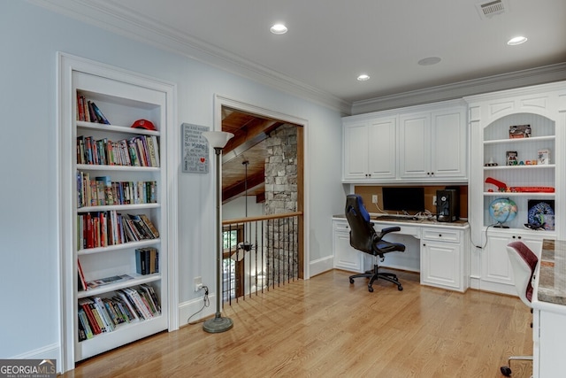 office featuring crown molding, built in desk, built in features, and light wood-type flooring