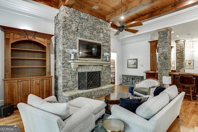 living room with a fireplace, beamed ceiling, ceiling fan, wood ceiling, and light hardwood / wood-style floors