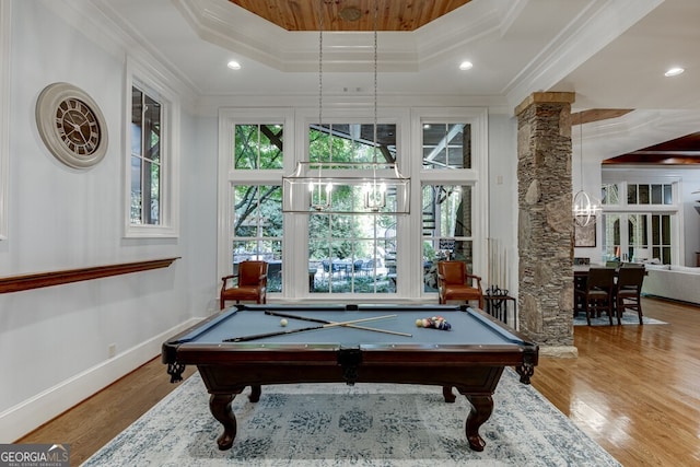 rec room with ornamental molding, plenty of natural light, hardwood / wood-style floors, and a tray ceiling