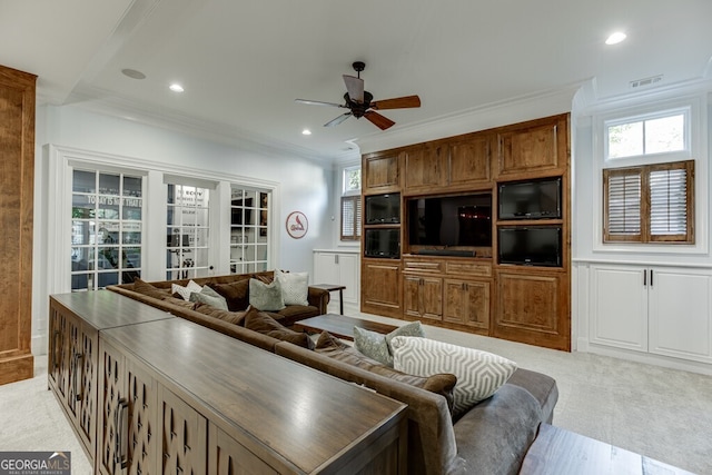 living room with crown molding, light colored carpet, and ceiling fan