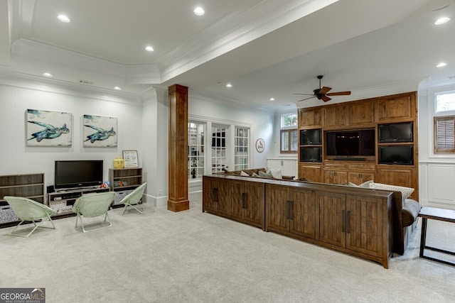 kitchen with ornate columns, ceiling fan, a raised ceiling, crown molding, and light carpet