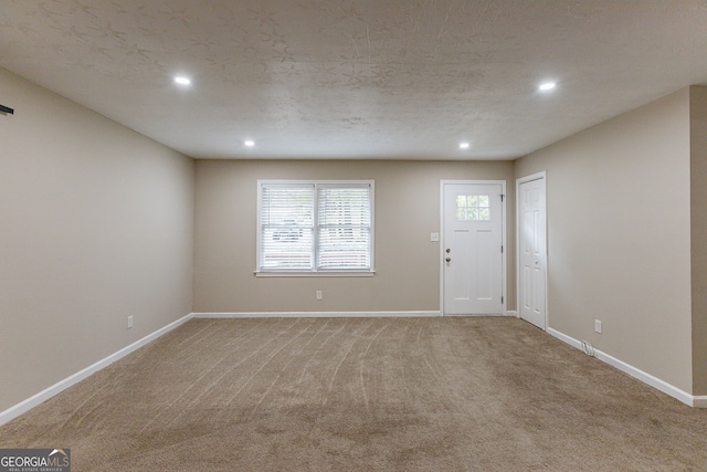 entryway with a textured ceiling and carpet flooring