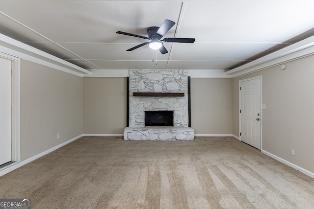 unfurnished living room with a stone fireplace, light colored carpet, and ceiling fan