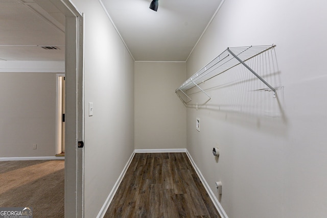 laundry area with dark wood-type flooring and crown molding