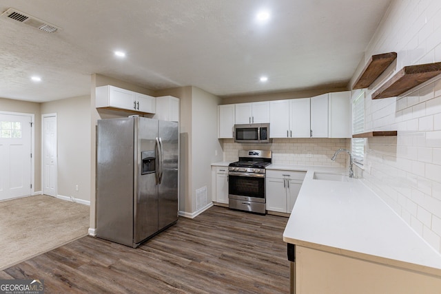 kitchen with sink, white cabinetry, stainless steel appliances, and dark hardwood / wood-style floors