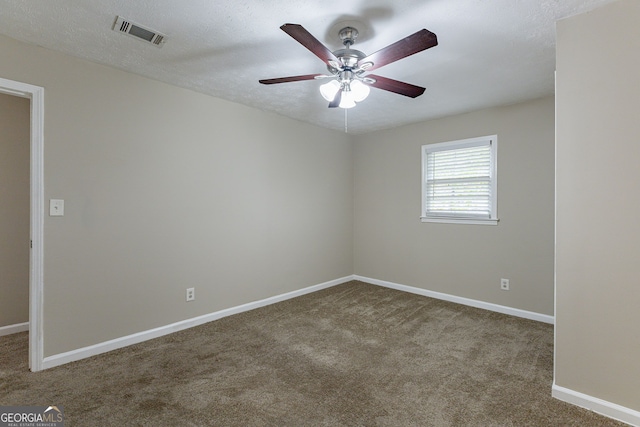 carpeted spare room featuring a textured ceiling and ceiling fan